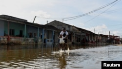 Un hombre recorre en bicicleta una calle inundada mientras el huracán Milton se acerca a la costa cubana en Batabano, Cuba, el 8 de octubre de 2024. REUTERS/Norlys Perez