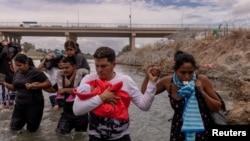 Yusniel, migrante de Cuba, con su hijo de 10 días de edad, y su esposa, Yanara, en el Río Grande, en la frontera sur de Estados Unidos, el 6 de octubre de 2023. (REUTERS/Adrees Latif/File Photo).