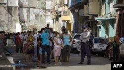 La policía controla la cola en una de las nuevas tiendas en dólares. (Adalberto ROQUE / AFP)